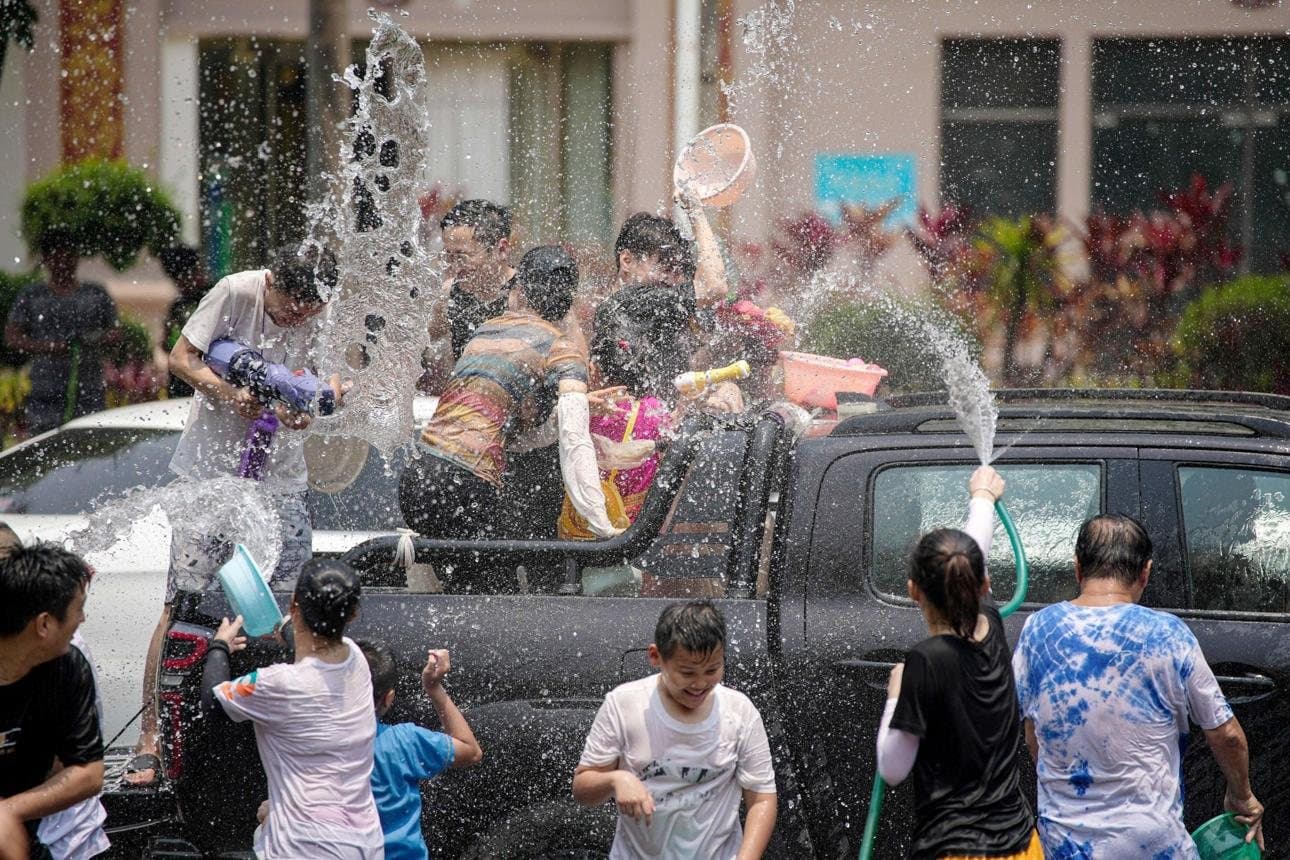 Festivals of Yunnan — neighbors splashing water in a village lane