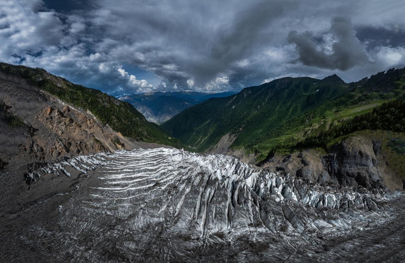 Nature and Wildlife of Yunnan — a glacier below storm clouds