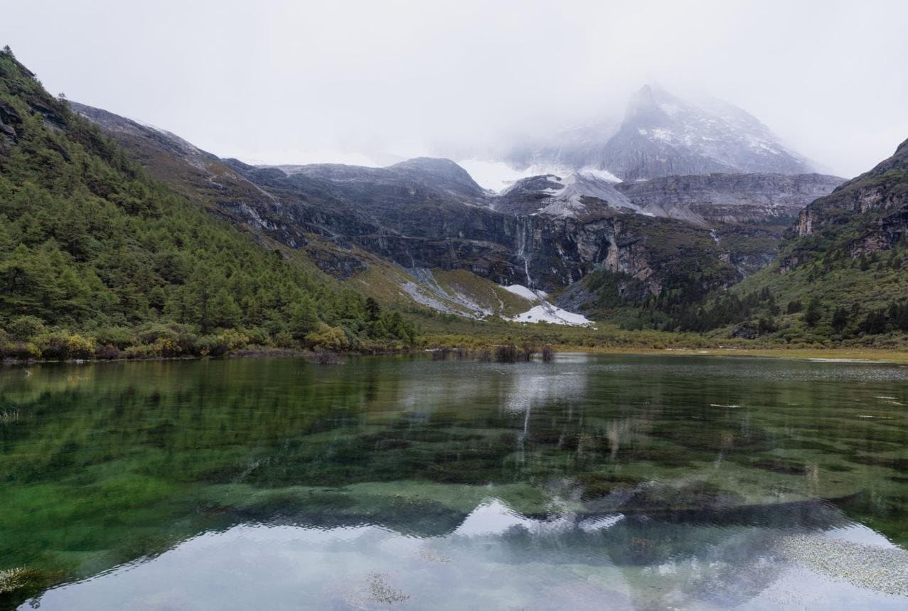 Nature and Wildlife of Yunnan — an alpine lake beneath misty peaks