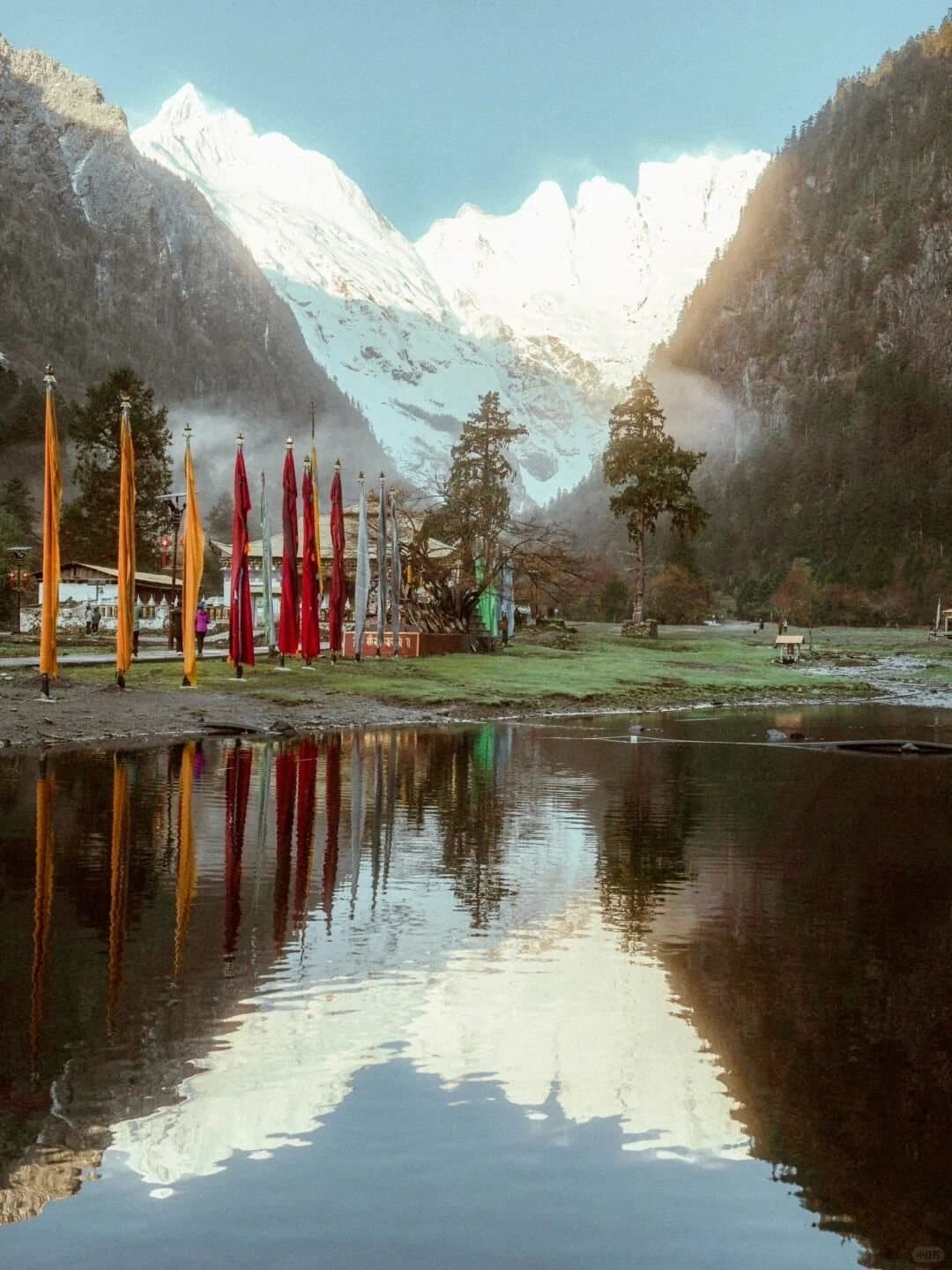 Yubeng Village — a reflective lake and prayer flags in Yubeng