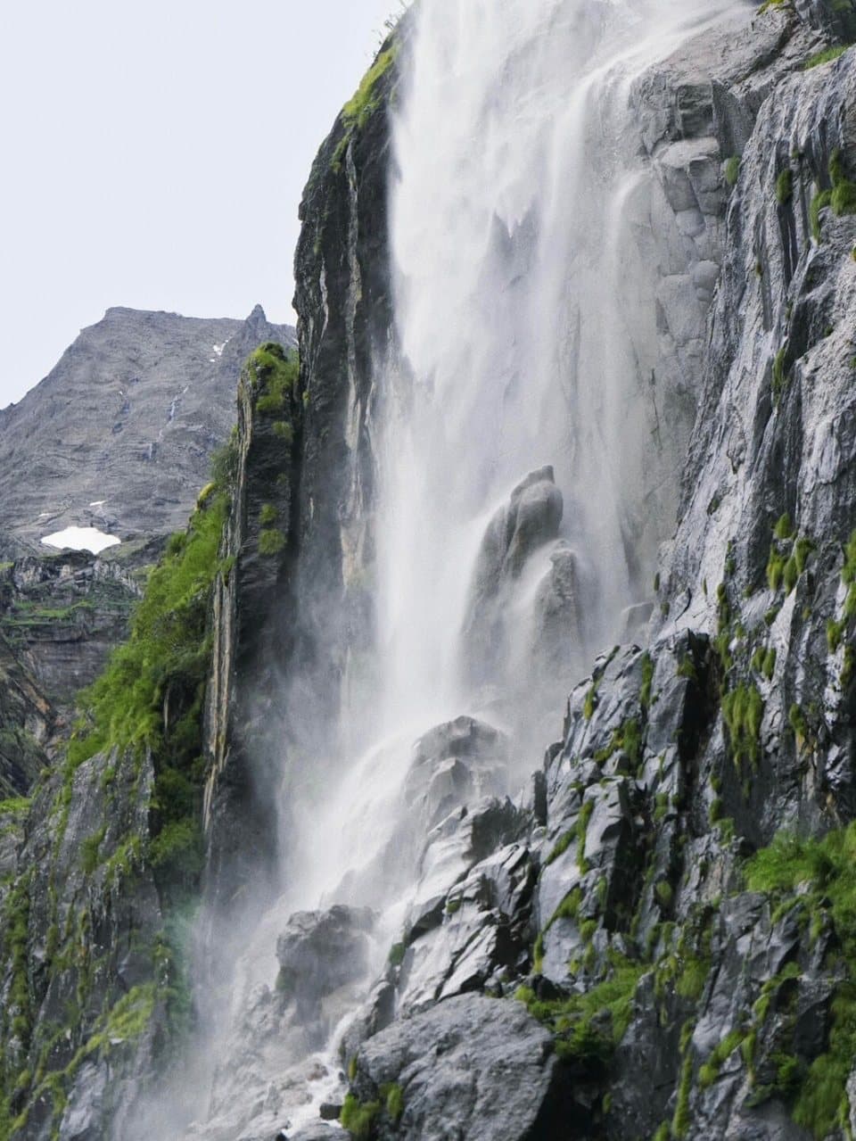 Yubeng Village — a waterfall descending through dark cliffs