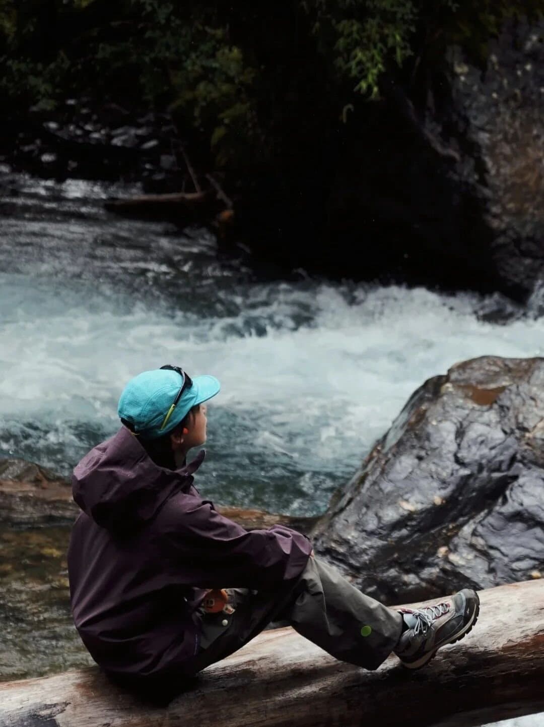 Yubeng Village — a hiker resting beside a forest stream