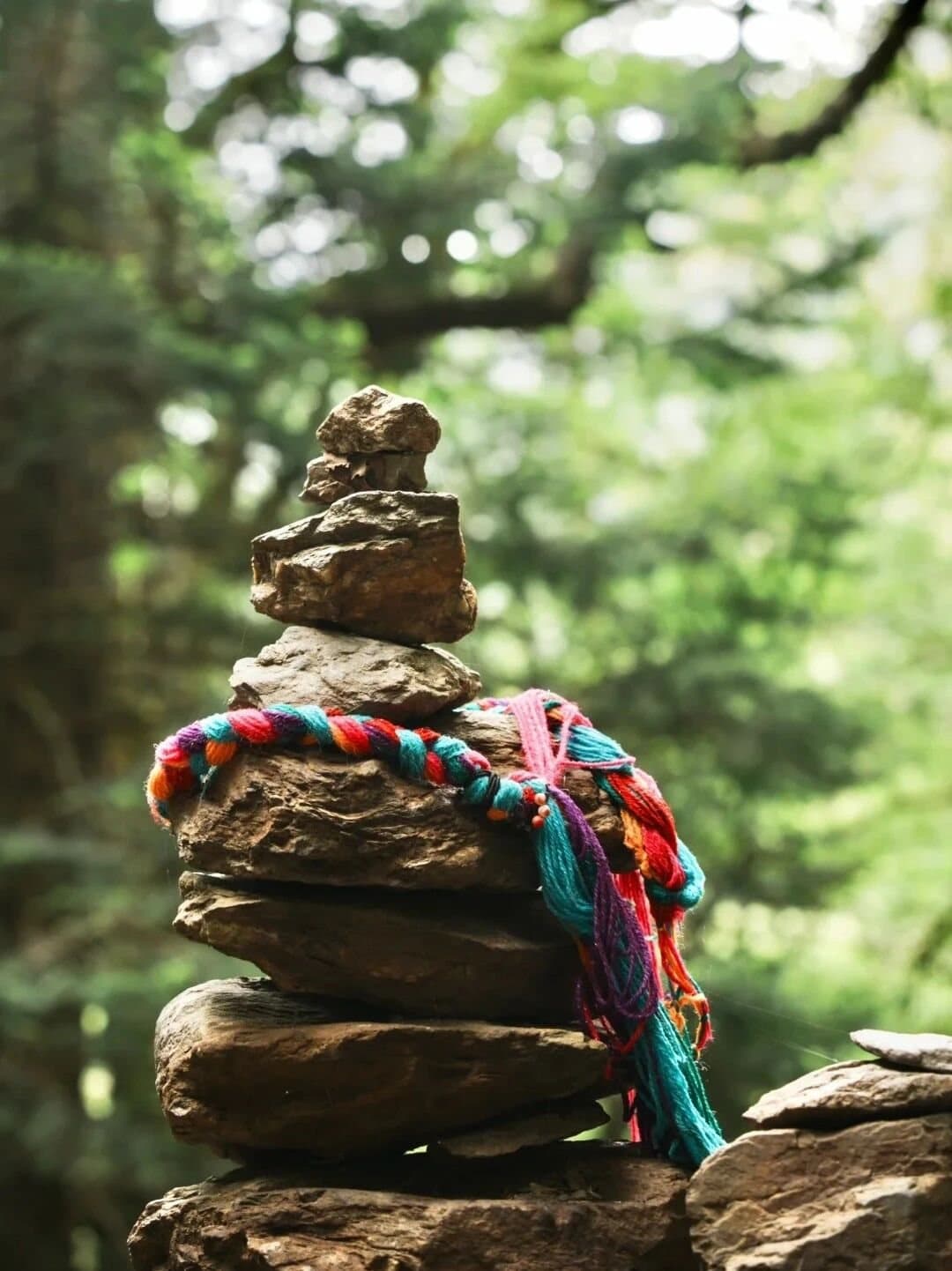Yubeng Village — a prayer-wrapped stone cairn in the woods