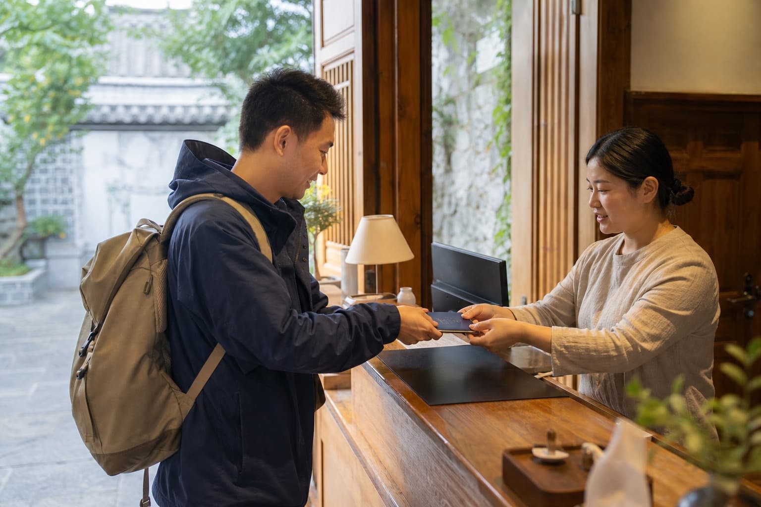 Traveler presenting a passport at a Yunnan hotel reception