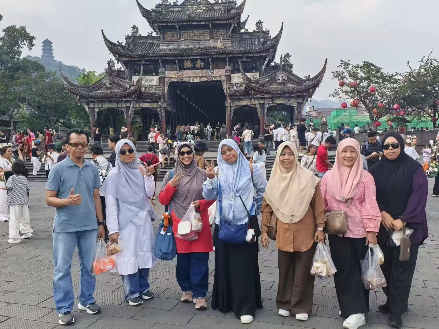 Travelers gathered in front of a traditional Yunnan gate